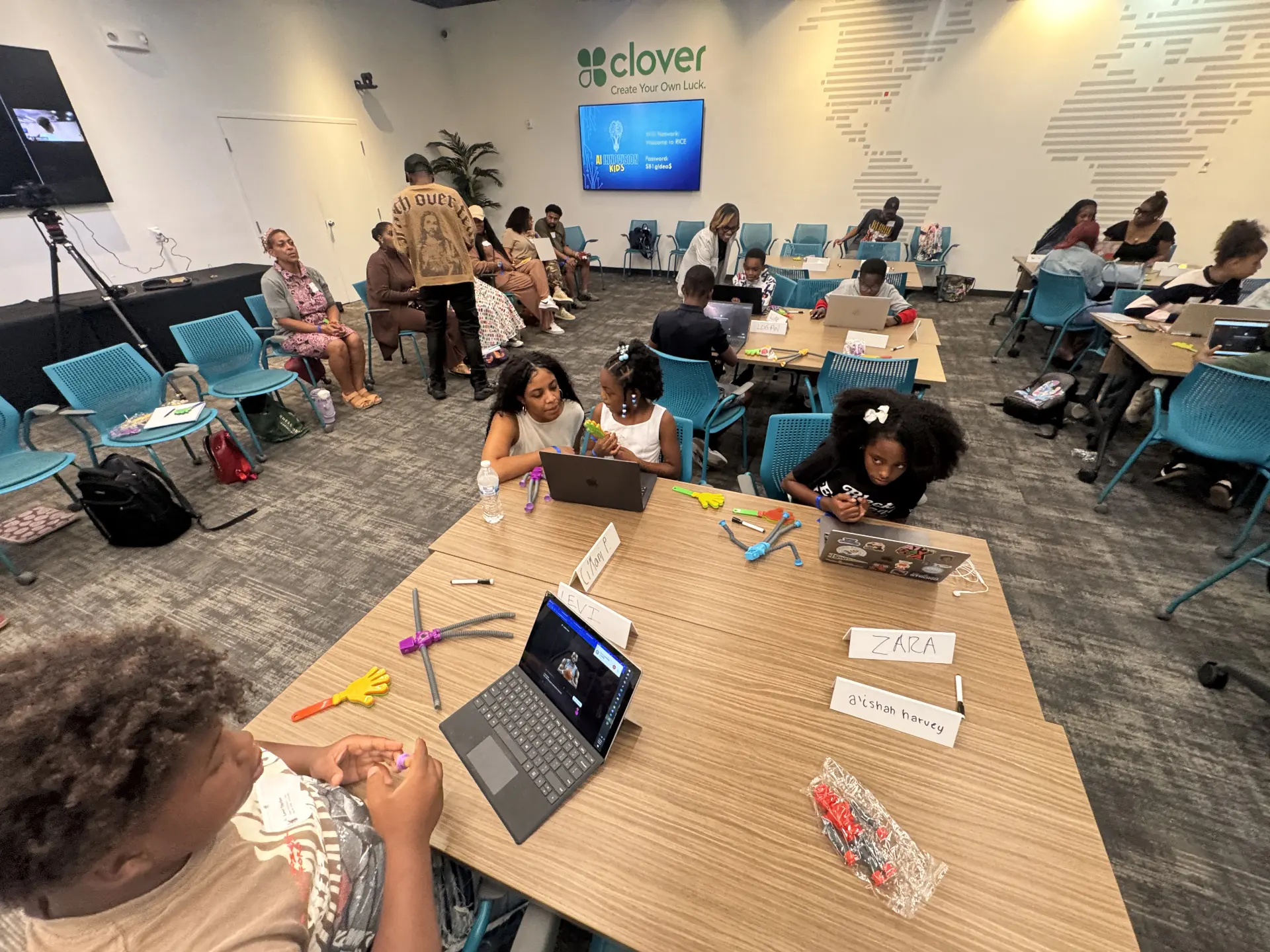 An adult and child working together on a laptop at a table during the AI workshop